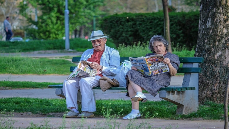 Old man and woman relaxing and reading
