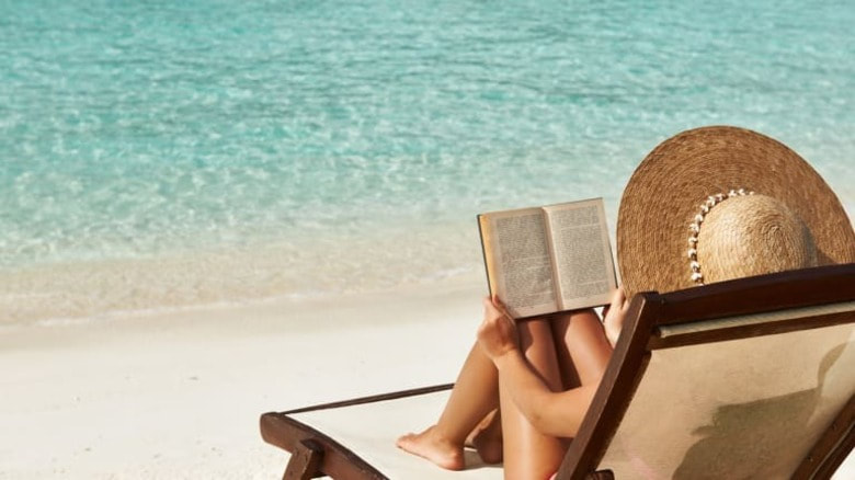 Woman reading novel on the beach